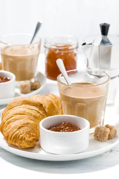 Koffie met melk en croissants met jam op witte tafel — Stockfoto