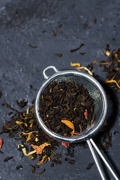 Сухой черный чай с травами в фильтре, вертикальный — стоковое фото
