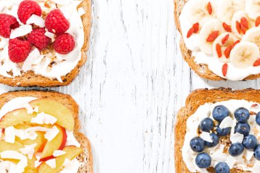 Beyaz ahşap masa üzerinde farklı Topingler ile tatlı ekmeği