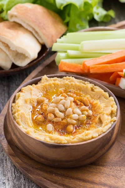 Hummus traditionnel dans un bol avec pain pita et légumes — Photo