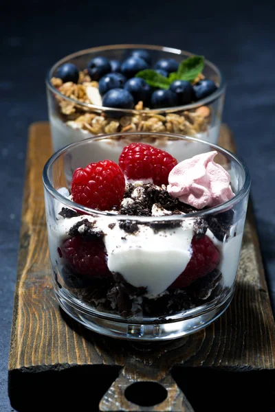 Various desserts with fresh berries and cream on dark background — Stock Photo, Image