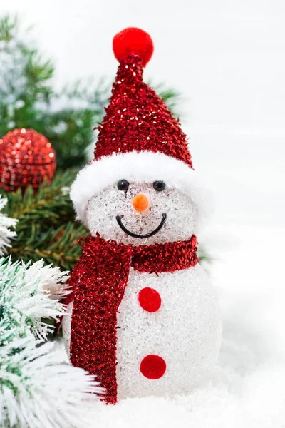 Jul snögubbe i fir grenar på en vit bakgrund, närbild — Stockfoto