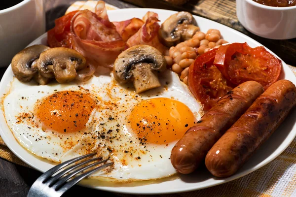 Gebratene Eier mit Speck, Würstchen und Gemüse, Nahaufnahme — Stockfoto