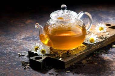 cam çaydanlık kokulu papatya çayı ve koyu arka plan