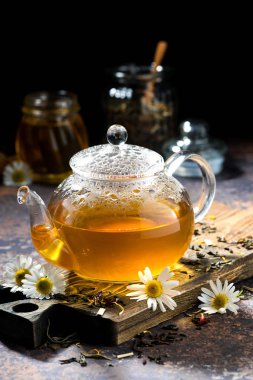 güzel kokulu papatya çayı koyu arka plan üzerinde cam çaydanlık