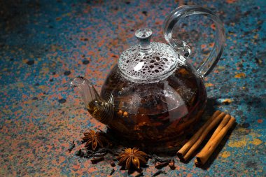 karanlık bir arka plan, üstten görünüm üzerinde bir cam demlik çay masala