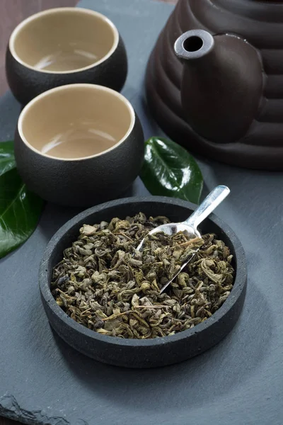 Groene thee in een keramische kom en thee gebruiksvoorwerpen — Stockfoto