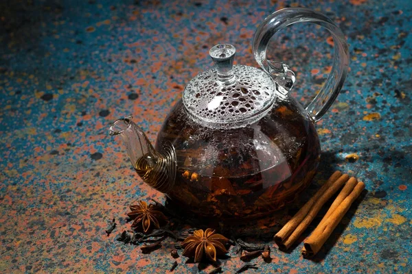 karanlık bir arka plan, üstten görünüm üzerinde bir cam demlik çay masala