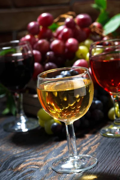 Sortiment verschiedene Weine auf dunklem Holztisch, senkrecht — Stockfoto