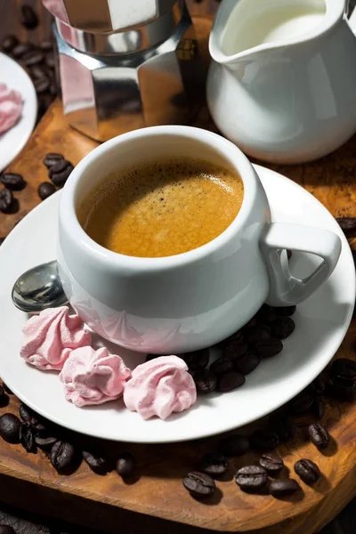 Taze espresso ve ahşap masa, dikey olarak pembe meringues — Stok fotoğraf