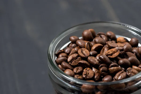 Purkki kahvipapuja puupohjalla, konsepti kuva — kuvapankkivalokuva