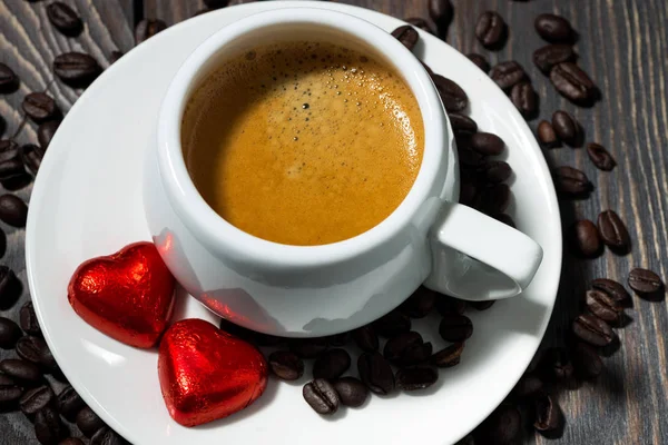 Tazza di caffè espresso e caramelle al cioccolato a forma di cuore — Foto Stock