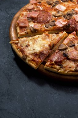Peynir ve sosis karanlık bir arka plan, dikey olarak pizza