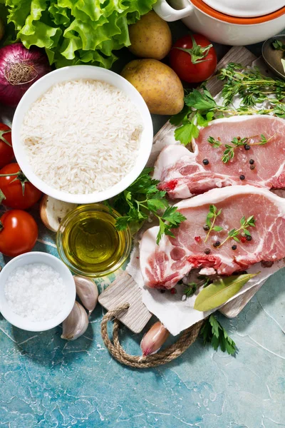 Two pieces of pork on a cutting board and fresh foods — Stock Photo, Image