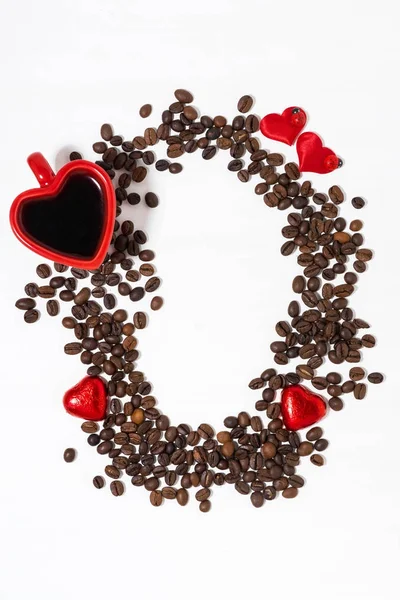 Кавові зерна, чашка кави та шоколадні цукерки — стокове фото