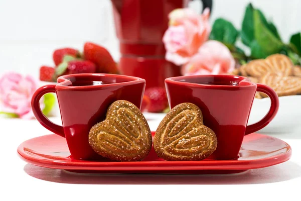 Deux tasses à café rouges et biscuits en forme de coeur sur fond blanc — Photo