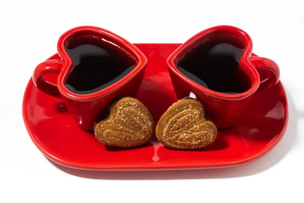 Tazze di caffè rosso e biscotti a forma di cuore su sfondo bianco — Foto Stock