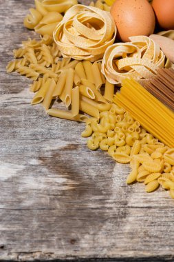 farklı kuru makarna üzerine bir tahta masa, üstten görünüm dikey