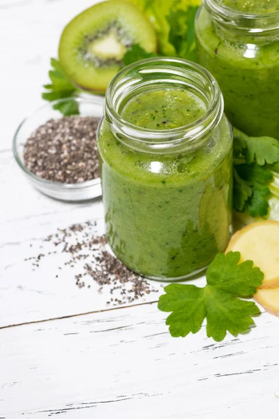 Batidos de frutas y verduras verdes en frascos sobre mesa blanca — Foto de Stock