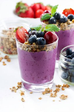 Yaban mersini tatlı ile beyaz bir arka planda, dikey granola