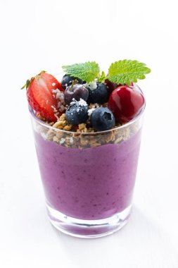 Böğürtlenli yoğurt ile beyaz bir arka planda, dikey granola