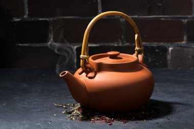 karanlık bir arka plan üzerinde kahverengi seramik çaydanlık