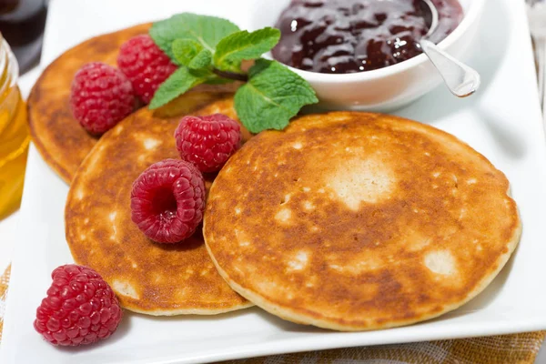 Deliciosos panqueques con frambuesas y mermelada para el desayuno — Foto de Stock
