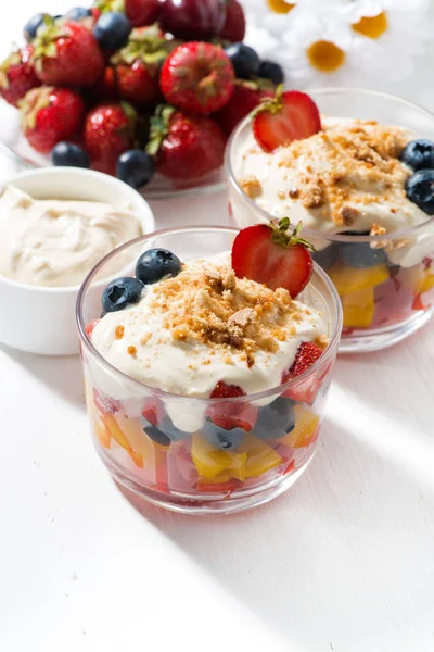 Surtido de fruta fresca con natillas en mesa blanca, vertical — Foto de Stock