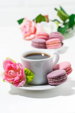 acıbadem kurabiyesi kurabiye, fincan kahve ve beyaz masaya çiçek