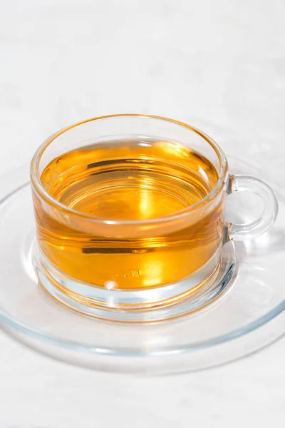 Ароматный чай в стеклянной чашке на белом фоне, вертикальный — стоковое фото
