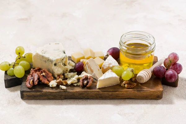 Сырная доска, виноград и мед на белом фоне, вид сверху — стоковое фото