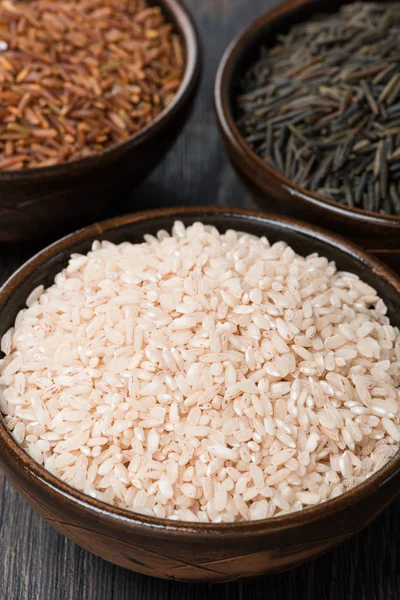 Tres tipos de arroz en cuenco de cerámica, primer plano — Foto de Stock