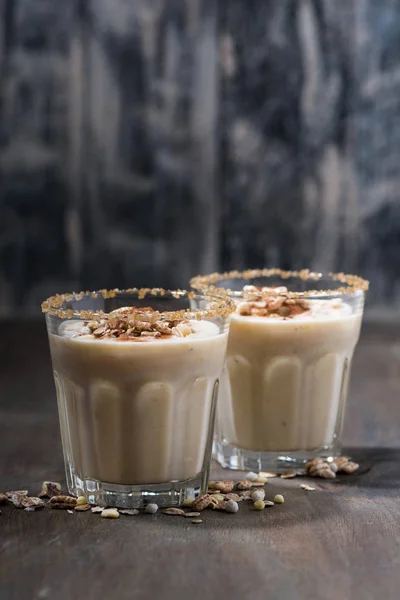 Creamy cocktail with muesli on dark background, vertical — Stock Photo, Image