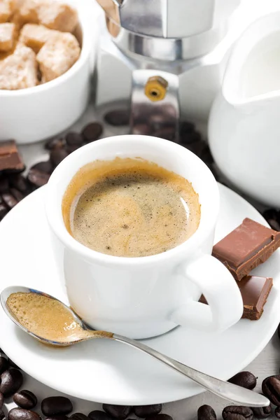 Kopp espresso, kaffebönor och sötsaker, närbild vertikala — Stockfoto