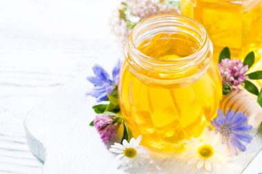 Beyaz ahşap tahta, üstten görünüm üzerinde taze çiçek bal kavanozlar 