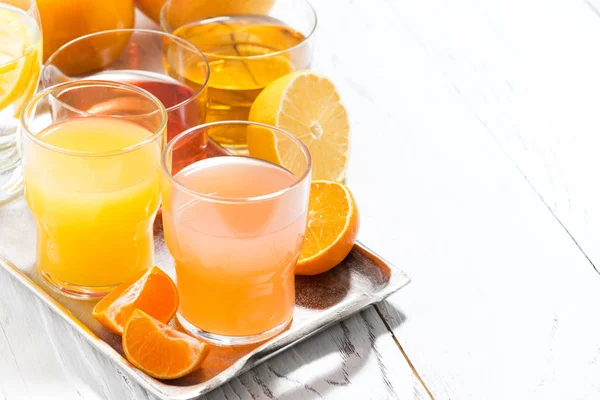 Assortment of fresh citrus juices on white table — Stock Photo, Image