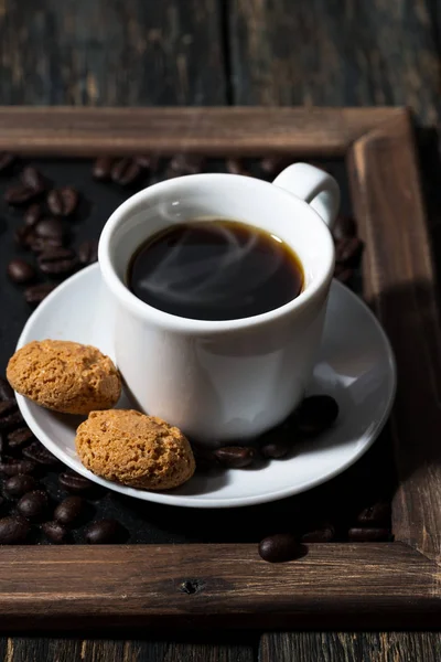 Xícara de café preto e biscoitos em uma bandeja, fecho vertical — Fotografia de Stock