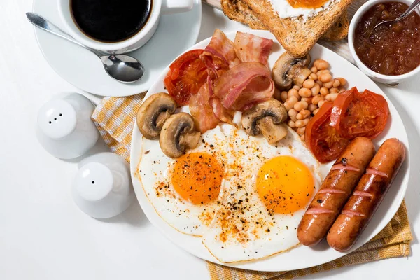 Английский завтрак из яичницы с беконом, сосисками — стоковое фото