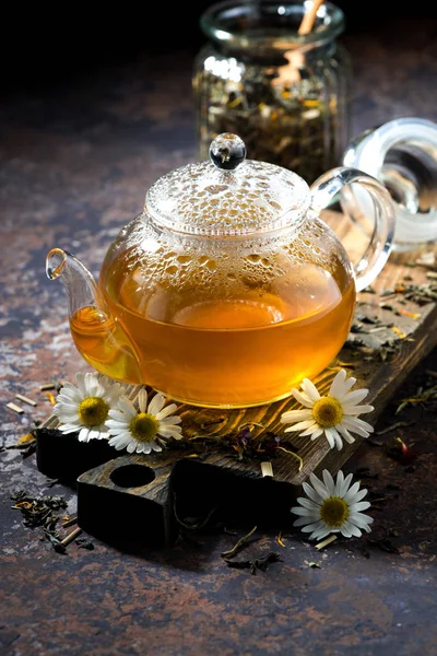 Fragrant chamomile tea in a glass teapot, vertical — Stock Photo, Image
