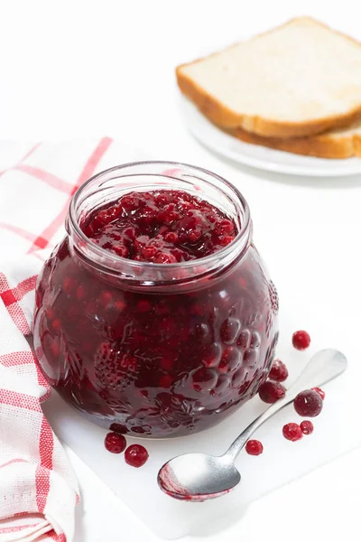 Jar of cranberry jam on a white table, vertical top view — Stock Photo, Image