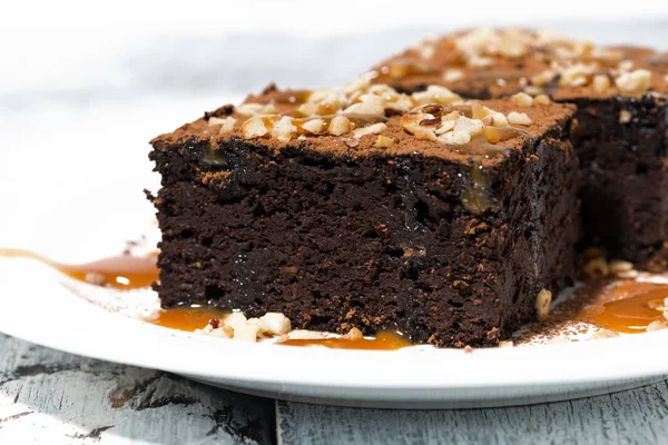El postre - los pedazos de los brownies de chocolate con la salsa de caramelo —  Fotos de Stock