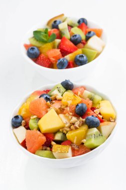 İki kase meyve salatası beyaz masada, dikey