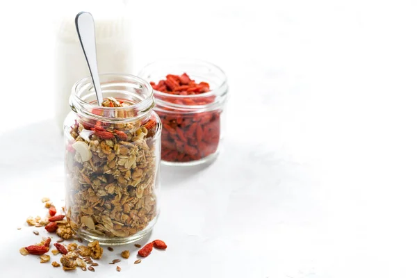 Healthy granola with goji berries in a glass jar — Stock Photo, Image