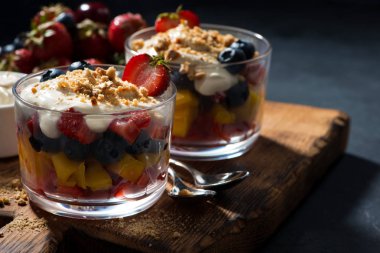 Gözlüklü bir ahşap tahta üzerinde muhallebi ile çeşitli taze meyve