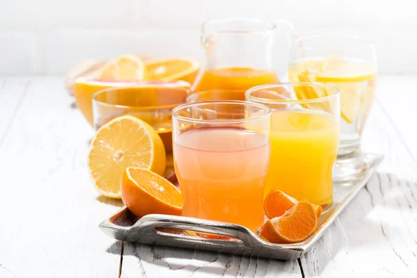 Fresh citrus juices on white table, closeup — Stock Photo, Image