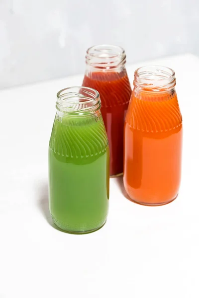 Colorful vegetable juices in bottles on white background — Stock Photo, Image