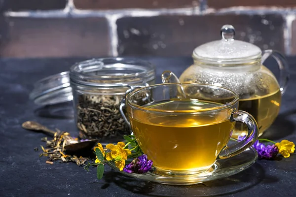 Cup of tea with aromatic herbs on a dark table — Stock Photo, Image