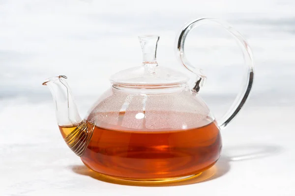 Чай в стеклянном чайнике на белом фоне — стоковое фото