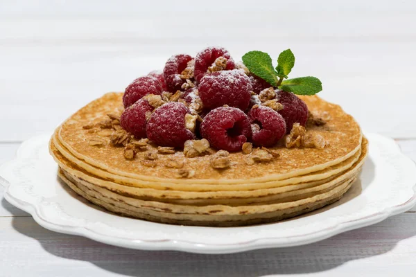 Traditional thin pancakes with fresh raspberries on wooden table — Stock Photo, Image