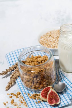 Sağlıklı yiyecekler - beyaz masada ev yapımı granola ve süt
